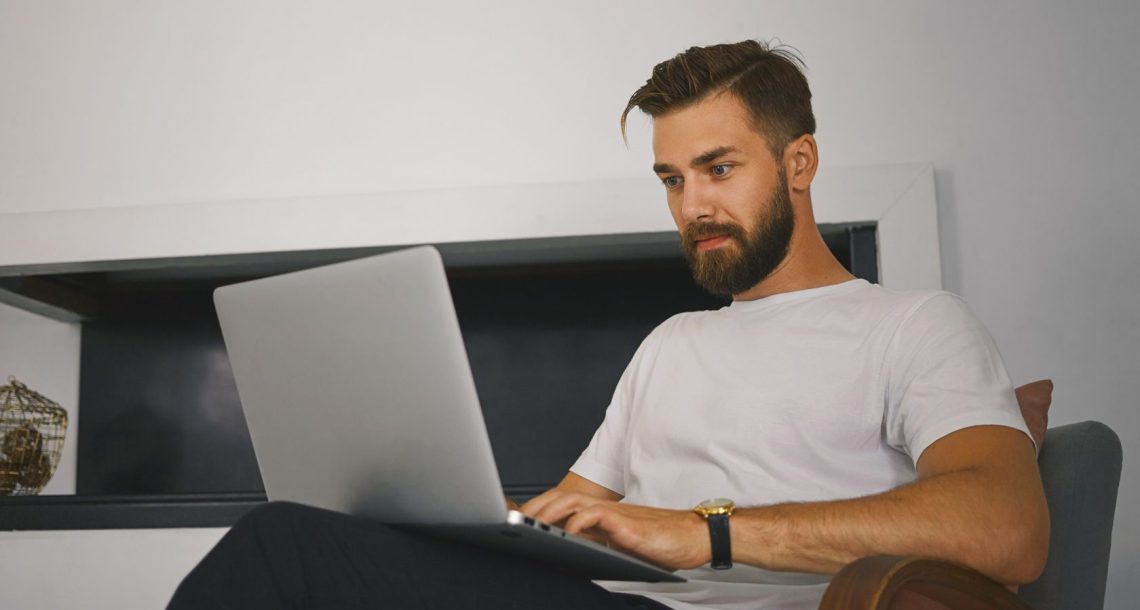muskarac prati oglase na laptopu
