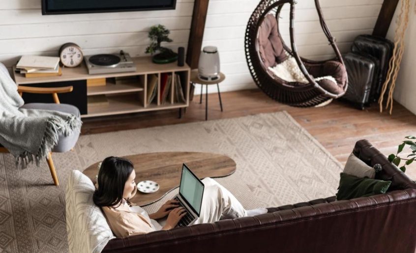 Devojka u sobi na krevetu gleda laptop