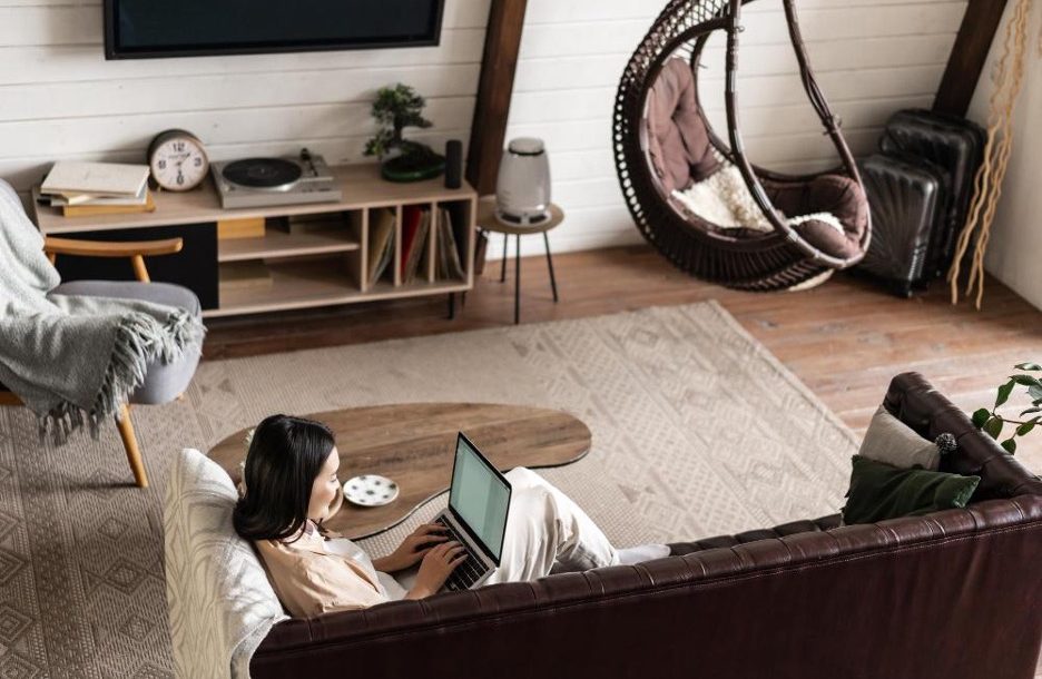 Devojka u sobi na krevetu gleda laptop